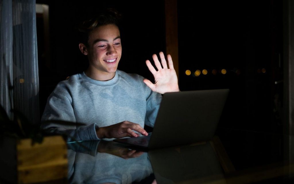 Na imagem, vemos um estudante participando de uma aula online. Ele faz isso implementando o que aprendeu sobre o que é educação socioemocional